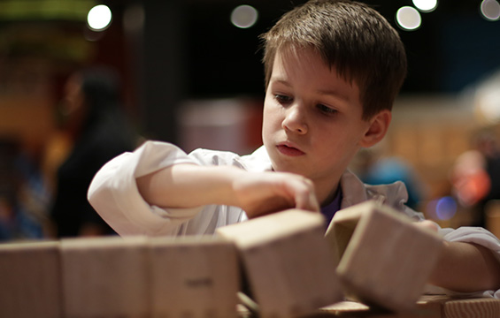 A young boy playing with wooden blocks at the Science Centre.