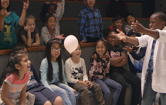 A group of students has fun learning about science with a balloon.
