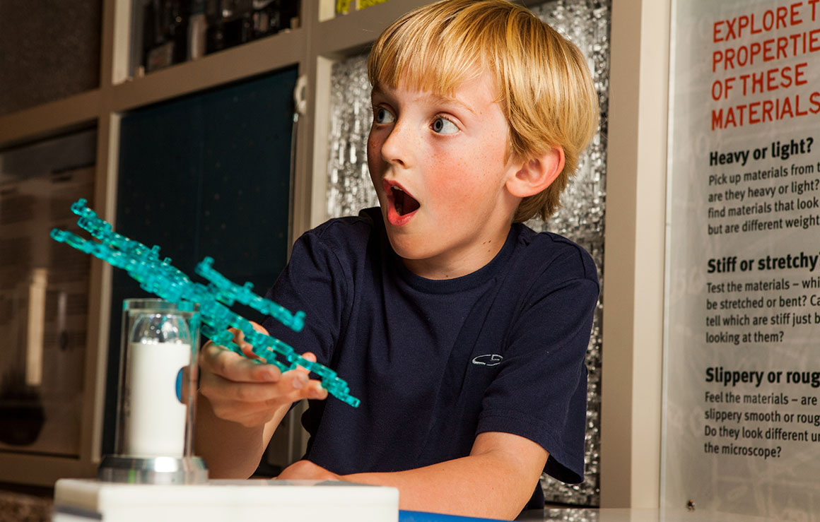 A boy expresses amazement at the new creation in his hands.