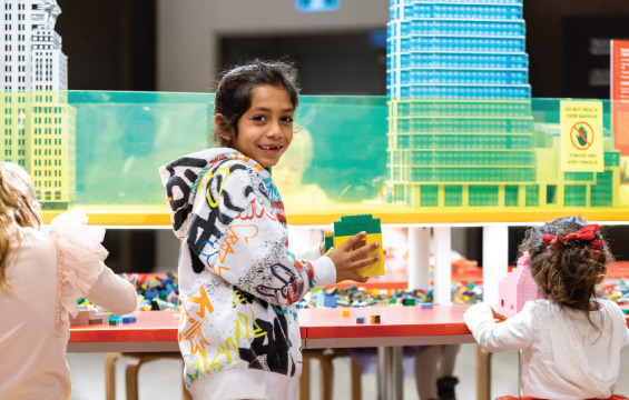 A child shows off their Lego creation in the Towers of Tomorrow exhibition.