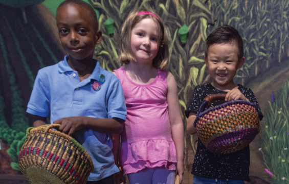 Three children in the garden exhibit in KidSpark.