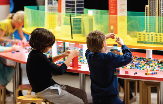 Two kids playing with the Lego blocks.